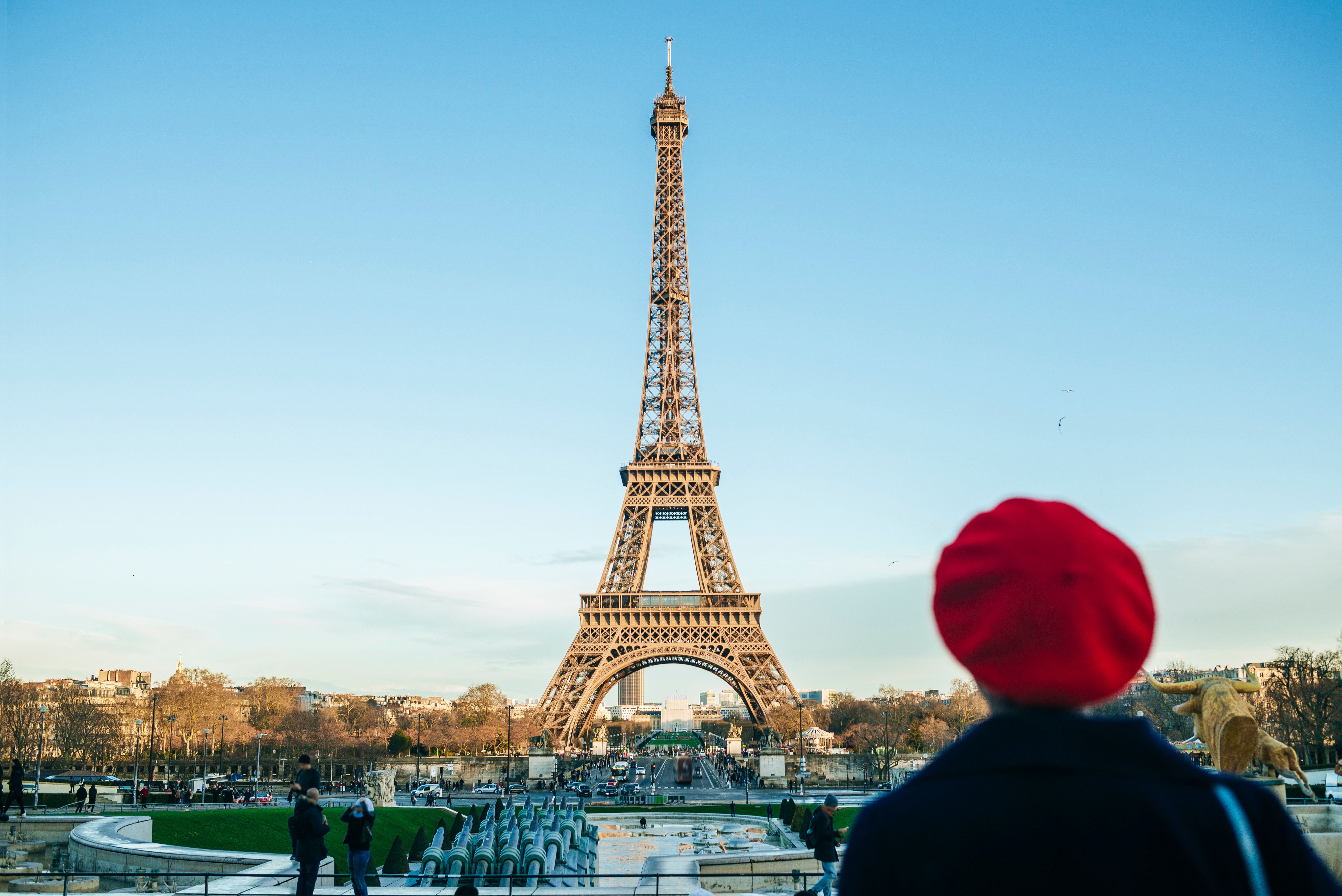 woman in red beret looks at eiffel tower