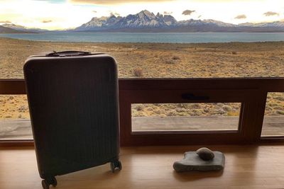 Brandless suitcase with lake and mountains in the background